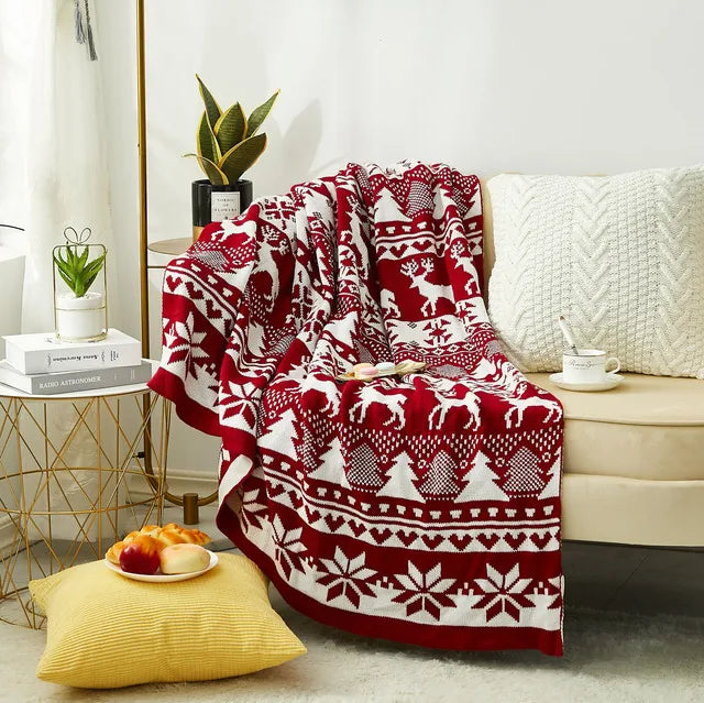 Soft red Christmas throw blanket with white reindeer and snowflake patterns, perfect for winter home decor. Ideal for keeping cosy and adding a festive touch to the living room or bedroom. Shop this warm, holiday-inspired throw at In Home Essentials for seasonal comfort and style.