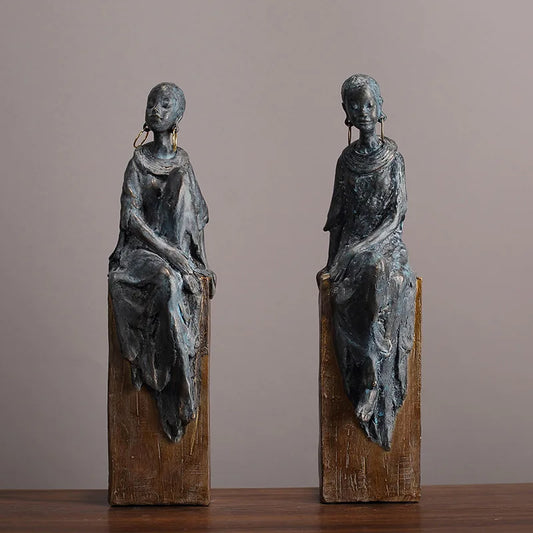 Resin African women sculptures with a retro, nostalgic style – perfect for contemporary or boho-chic spaces, featuring a wood-like base and oxidised metal finish.