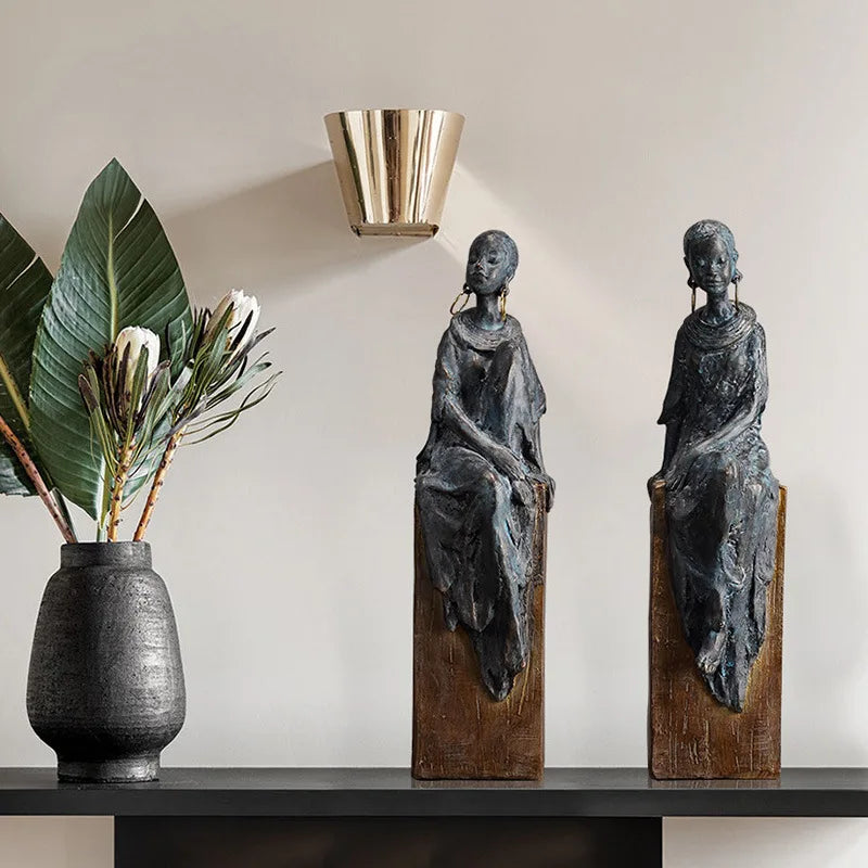 Resin African women sculptures with a retro, nostalgic style – perfect for contemporary or boho-chic spaces, featuring a wood-like base and oxidised metal finish.