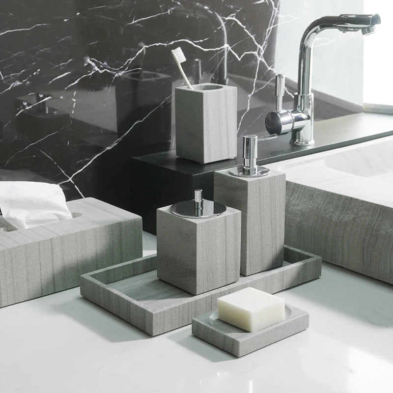 A sophisticated gray natural marble bathroom set, featuring a sleek soap dispenser, toothbrush holder, and soap dish, all crafted with premium marble for a modern and luxurious look.