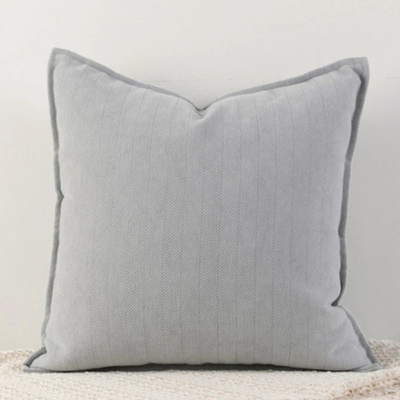 A space gray Nordic cushion cover placed over a couch, showcasing its delicate and cozy texture.