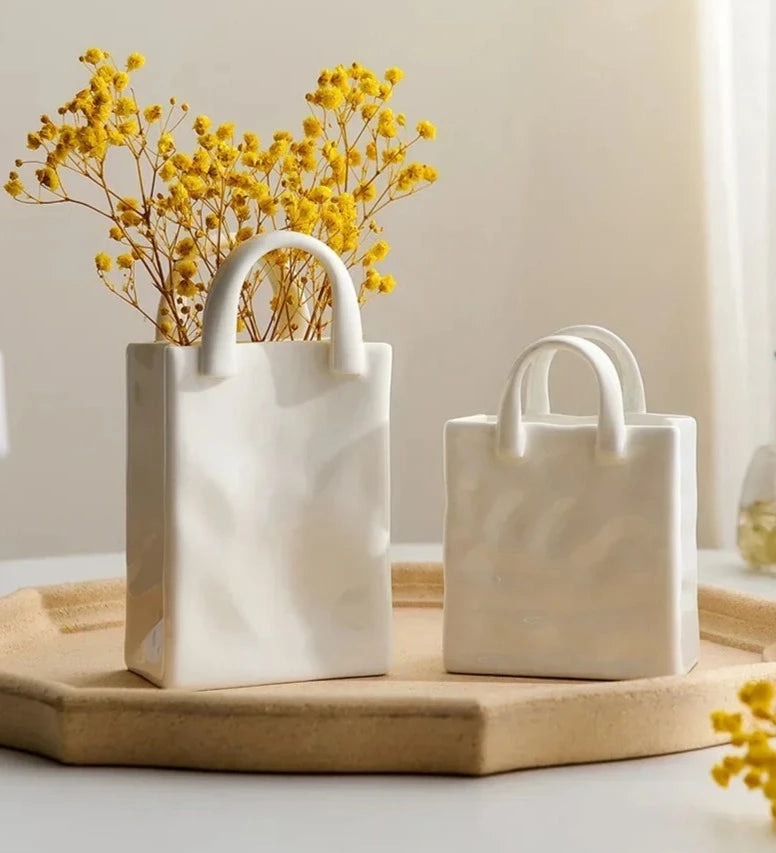 Two tote-style ceramic vases filled with flowers, showcasing their elegant design and functionality for modern and classic home decor.