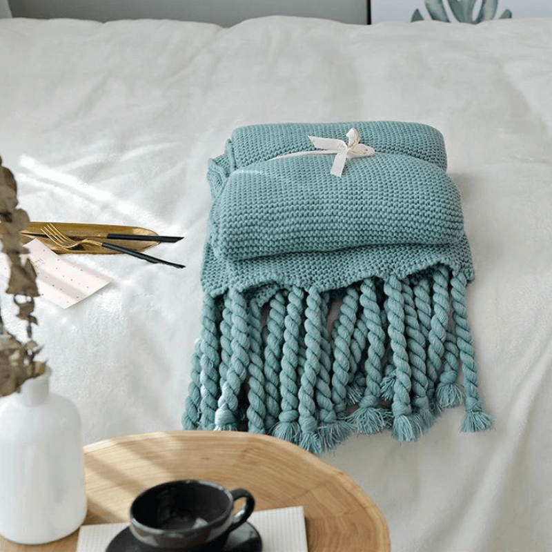 Cozy woven soft knit throw blanket in a warm neutral color.