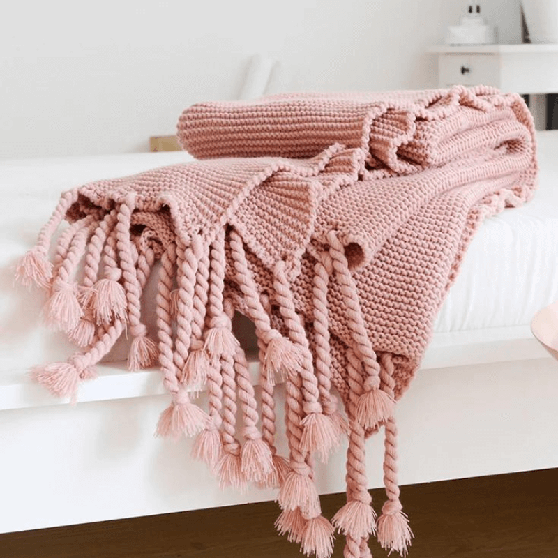 Cozy woven soft knit throw blanket in a warm neutral color.