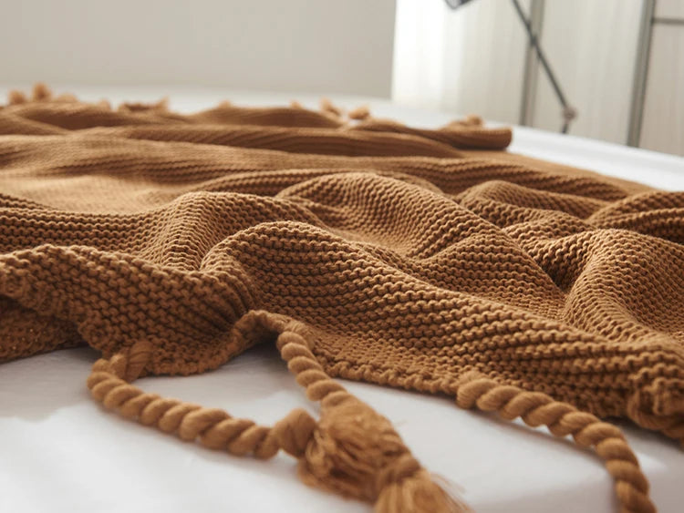 Cozy woven soft knit throw blanket in a warm neutral color.