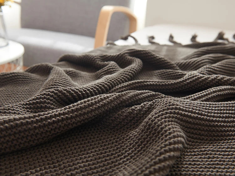 Cozy woven soft knit throw blanket in a warm neutral color.