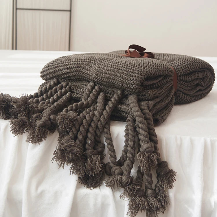 Cozy woven soft knit throw blanket in a warm neutral color.