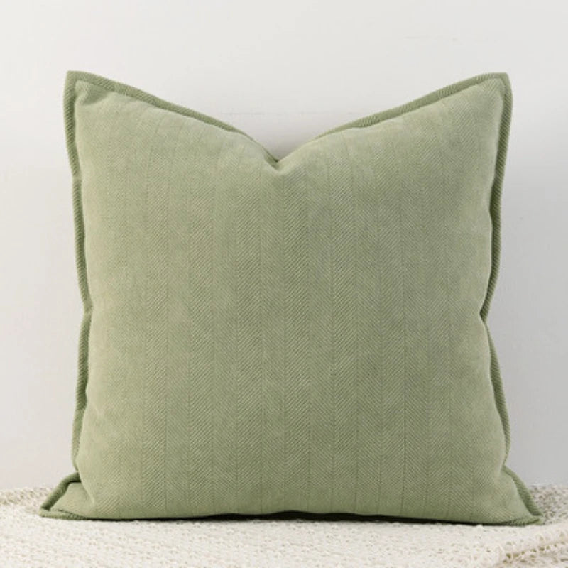 A yellow- green Nordic cushion cover placed over a couch, showcasing its delicate and cozy texture