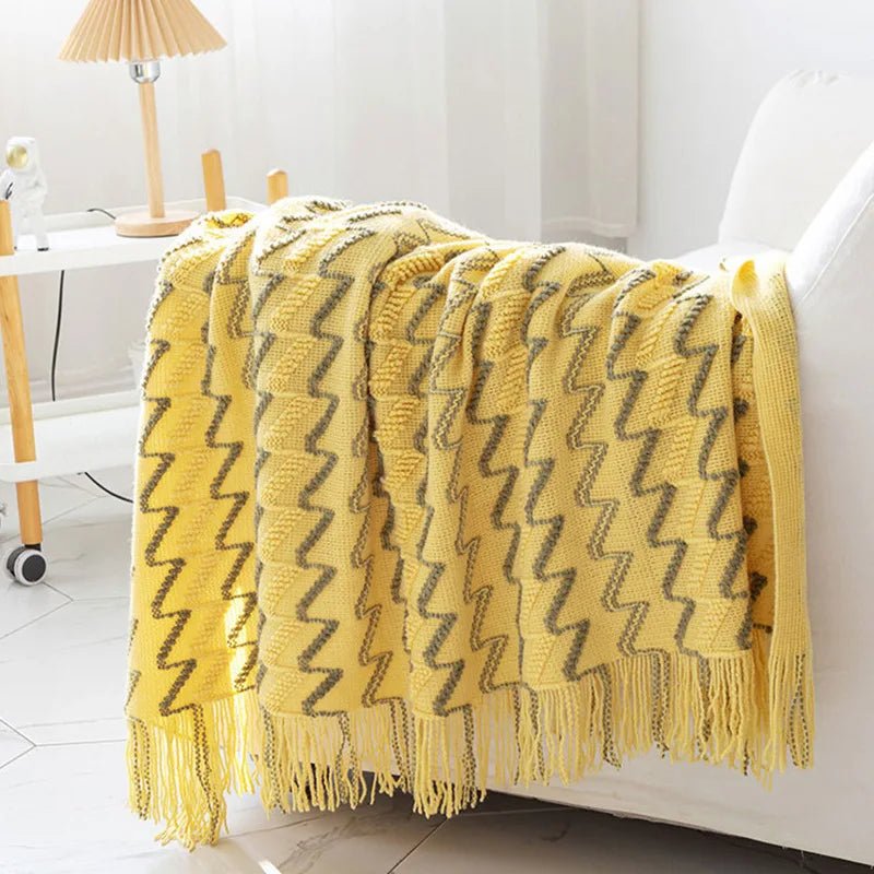 A yellow luxurious soft acrylic blanket draped over a couch, showcasing its soft and cozy texture.